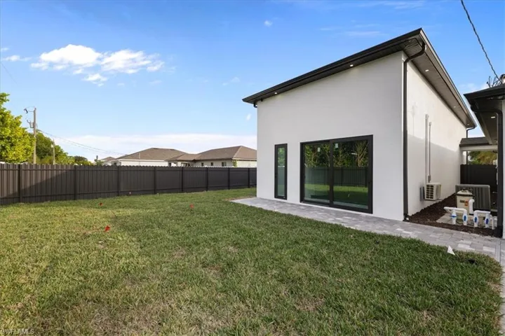 Back of property with a fenced backyard, stucco siding, and a patio area