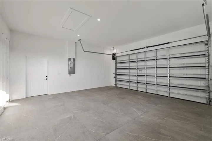 Garage featuring recessed lighting and electric panel