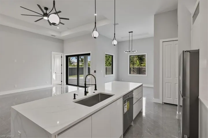 Kitchen featuring white cabinetry, light stone countertops, stainless steel appliances, modern cabinets, and recessed lighting