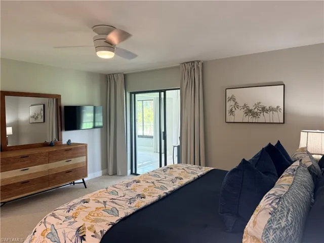Bedroom with access to exterior, light colored carpet, and a ceiling fan