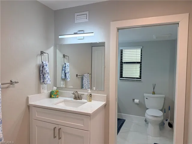 Bathroom featuring vanity and light marble finish flooring