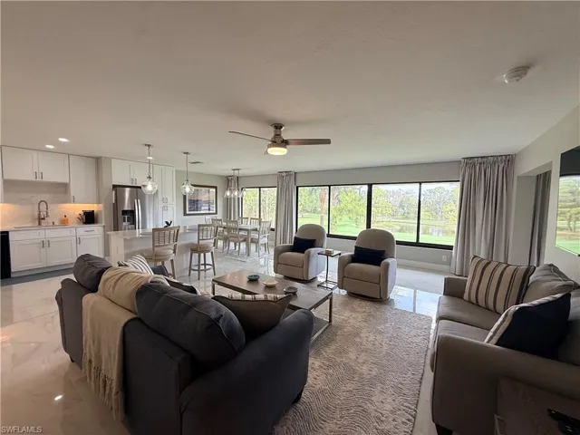 Living room with ceiling fan and light marble finish floors