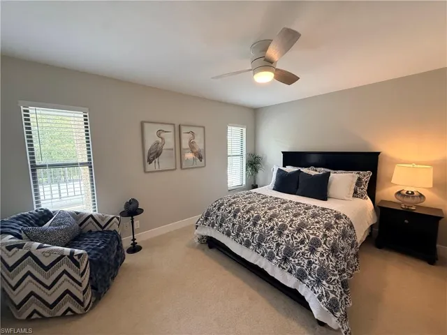 Carpeted bedroom with baseboards and a ceiling fan