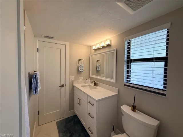 Half bath with vanity and a textured ceiling