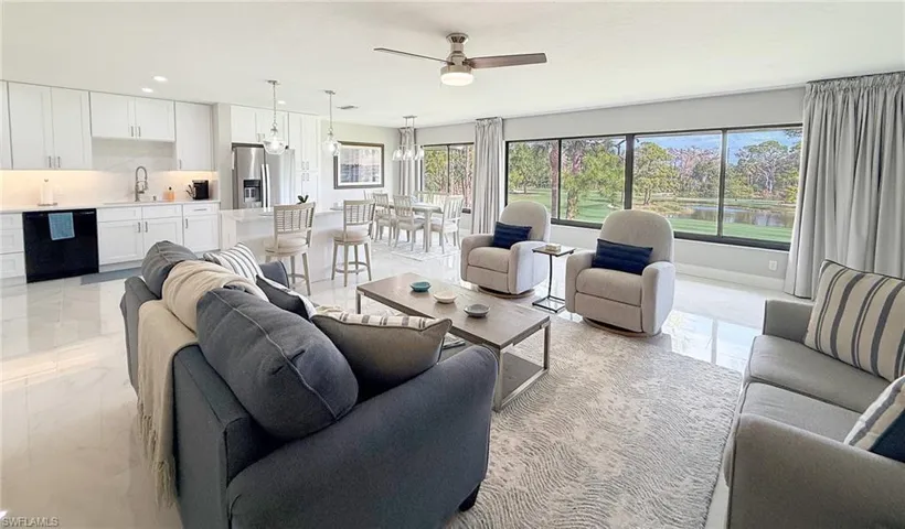 Living area with a ceiling fan, recessed lighting, and light marble finish flooring