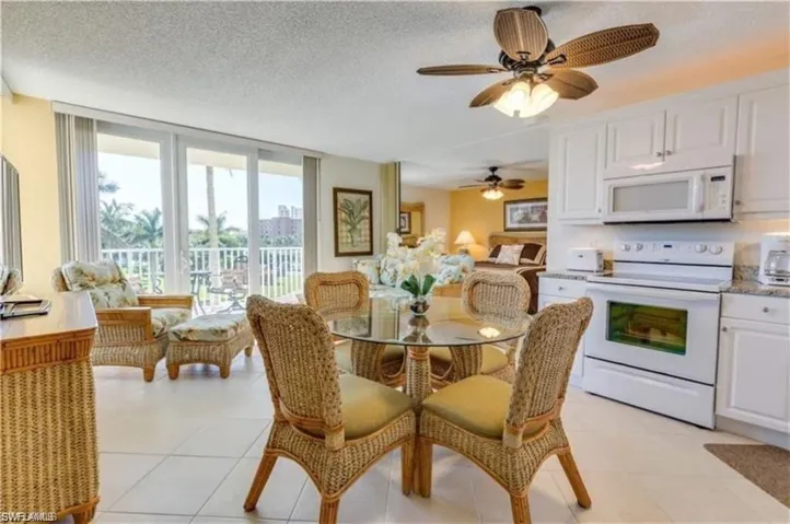 Tiled dining area with a textured ceiling and ceiling fan
