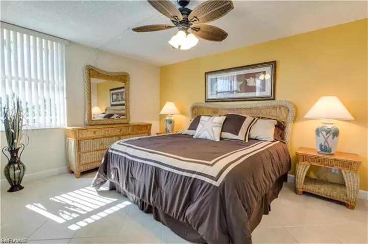 Bedroom with a textured ceiling, ceiling fan, and light tile patterned floors
