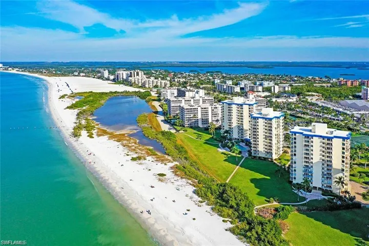 Birds eye view of property with a beach view and a water view