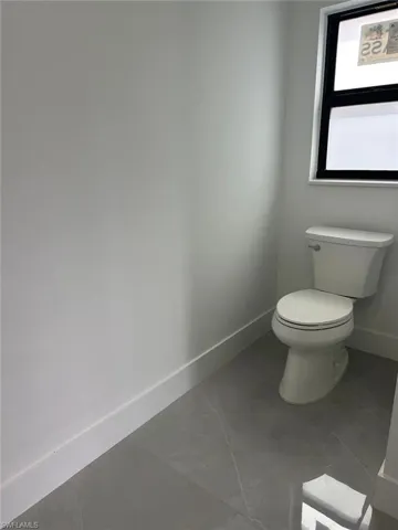 Bathroom featuring baseboards and toilet