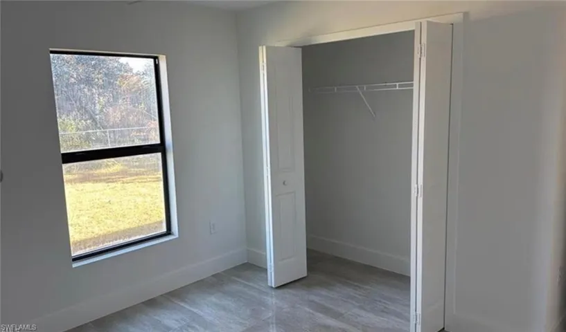 Unfurnished bedroom featuring a closet and baseboards