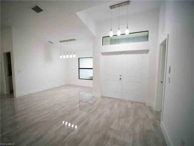 Entrance foyer featuring wood finished floors and a towering ceiling