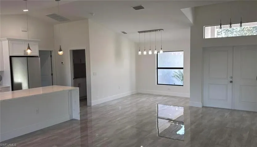 Entryway with high vaulted ceiling and light wood-type flooring