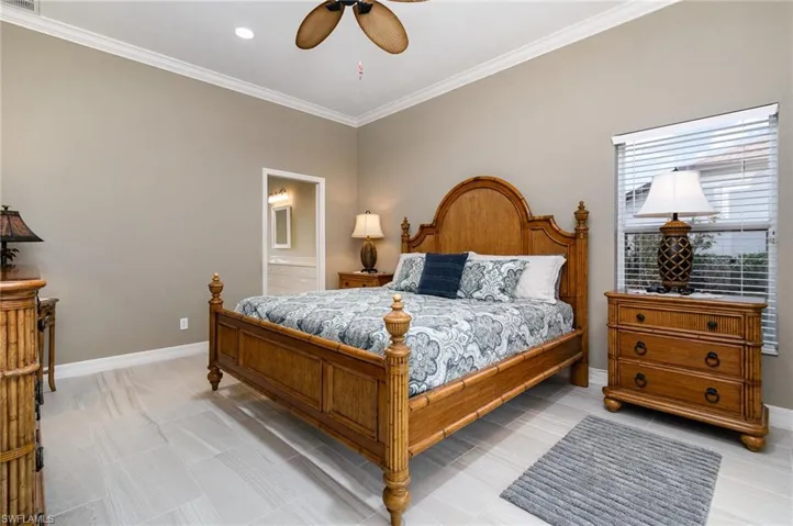 Primary Bedroom with ensuite bath, crown molding, and ceiling fan