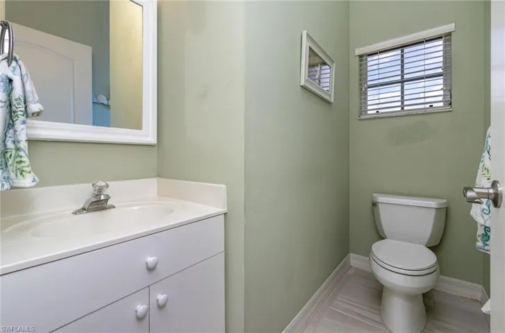 Hall Bathroom featuring tile floors, vanity, and toilet