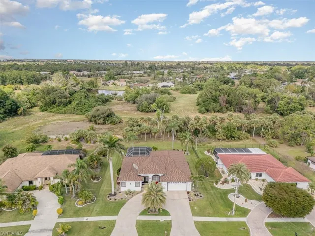 Drone / aerial view of home with circular pavered driveway,