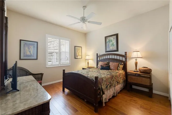 Bedroom 3, with Tommy Bahama furniture stays and tv stays, with wood finished floors and a ceiling fan and double closets.