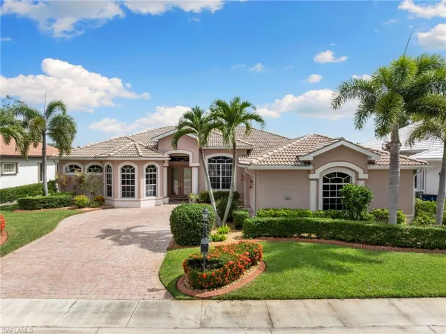 This home features 8' front doors, den doors, master bedroom doors. 14' foyer ceiling and 12' family room ceilings. Hardwood and tile floors, Tile roofing and  oversized lanai pool area. Overlooks the golf course with beautiful trees, guava tree and plants in the backyard.