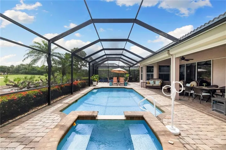 View of swimming pool featuring a pool with connected hot tub, a patio area, outdoor dining area, and ceiling fan