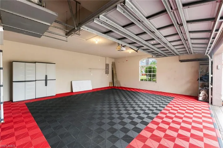 View of oversized 2.5 car garage, with custom flooring.