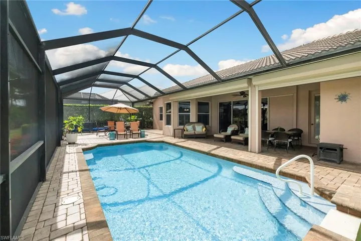 Outdoor pool with outdoor dining space, a patio area, outdoor lounge area, ceiling fan, and an oversized screened lanai area.