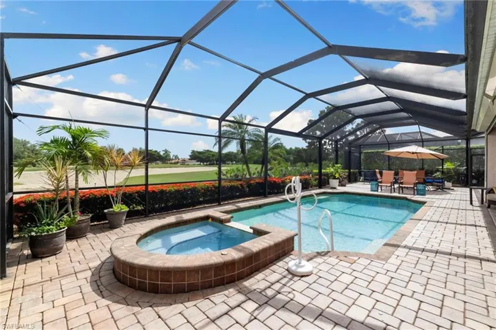 View of swimming pool with a patio area, a pool with connected hot tub, a lanai, and outdoor dining area