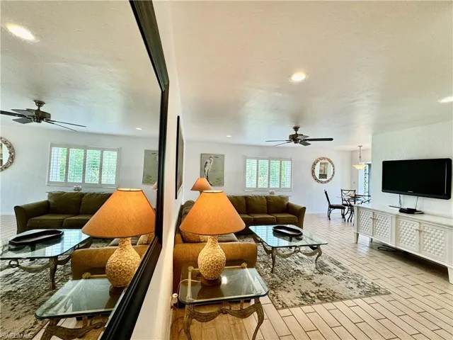 Living room featuring ceiling fan, a healthy amount of sunlight, and light hardwood / wood-style flooring
