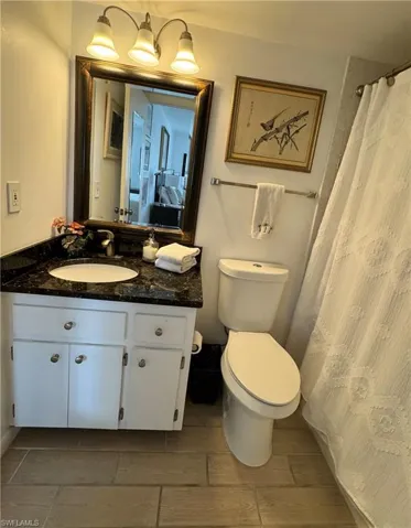 Bathroom featuring tile floors, vanity, and toilet