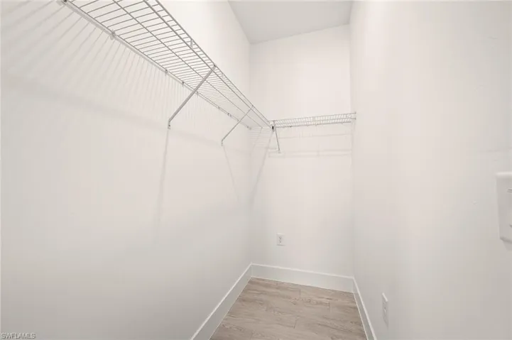 Spacious closet featuring light wood-style flooring