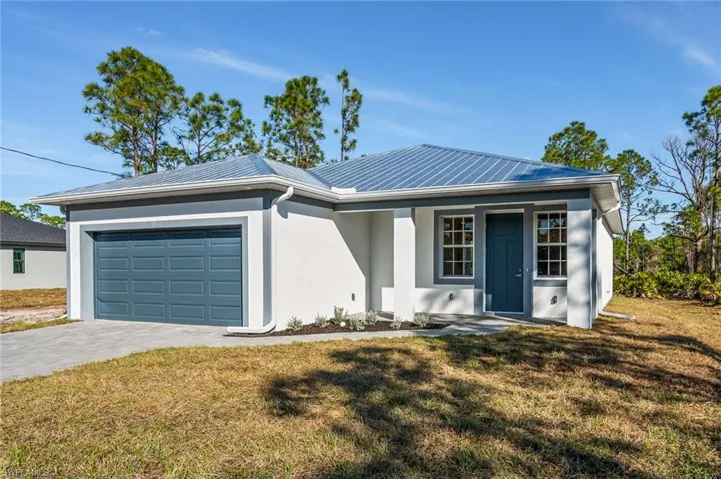 Single story home with decorative driveway, a front lawn, an attached garage, and stucco siding