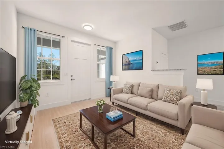 Living room with visible vents, baseboards, and wood finished floors