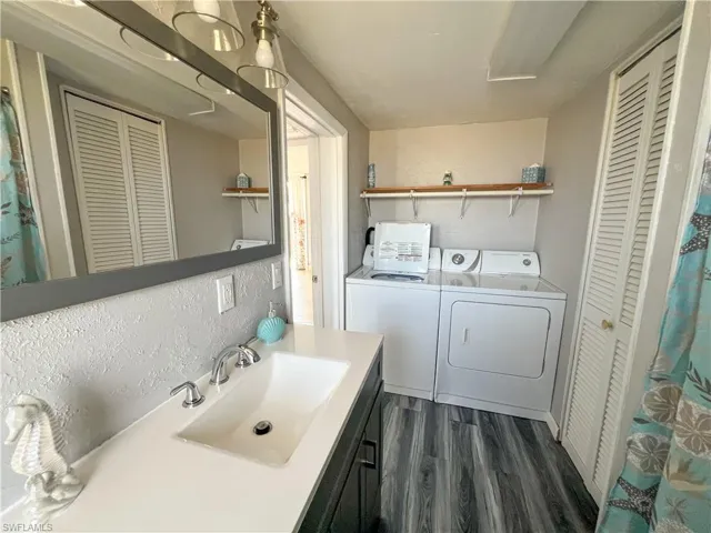 Bathroom 1 featuring independent washer and dryer, vanity, a closet, and wood finished floors