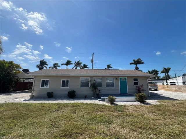 Single story home featuring a front lawn and fence