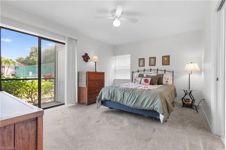 Primary bedroom with light-filled interior featuring a large sliding glass door.