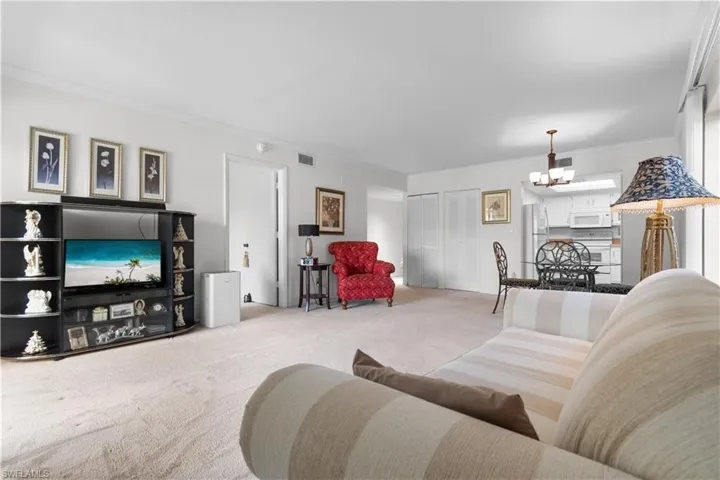 Spacious living area featuring neutral carpeting and white wall finishes