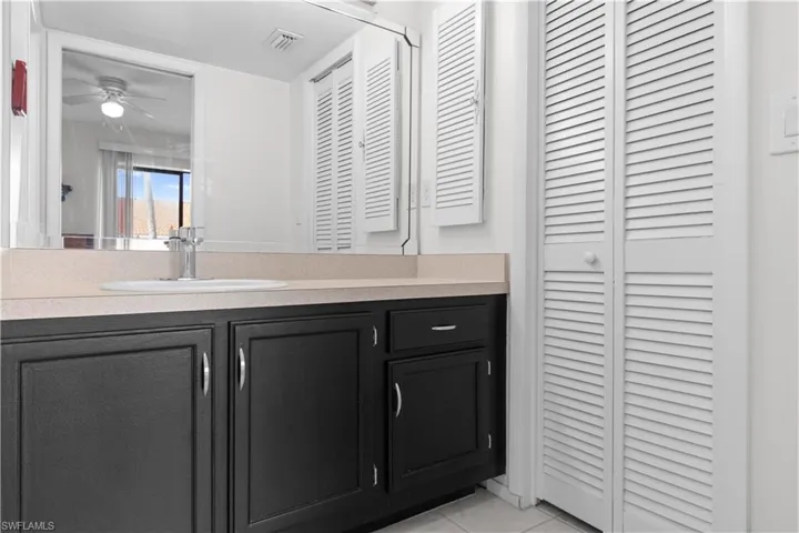 Bathroom vanity featuring black cabinetry and light-toned countertop.