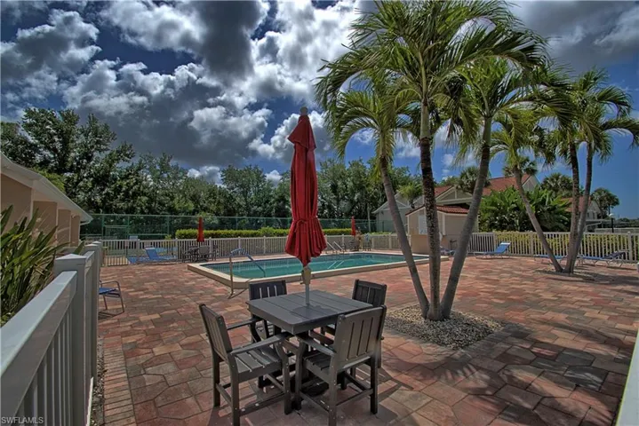 Expansive brick paver patio surrounding an in-ground swimming pool