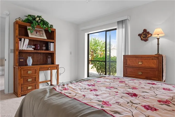 Bedroom featuring carpeted flooring, and a large sliding glass door.
