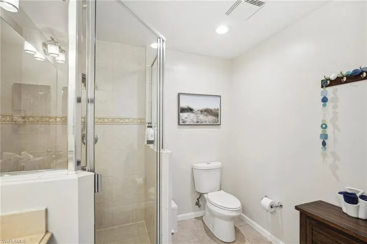 Bathroom featuring tile patterned floors, toilet, and walk in shower