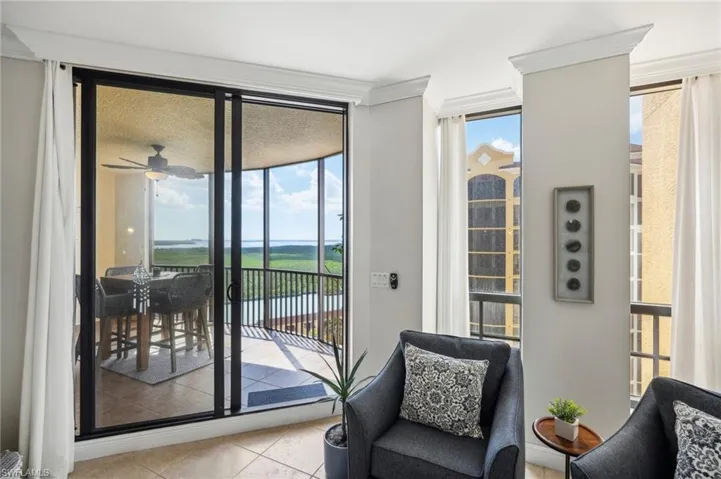 Doorway to outside featuring floor to ceiling windows, ceiling fan, light tile patterned floors, and plenty of natural light
