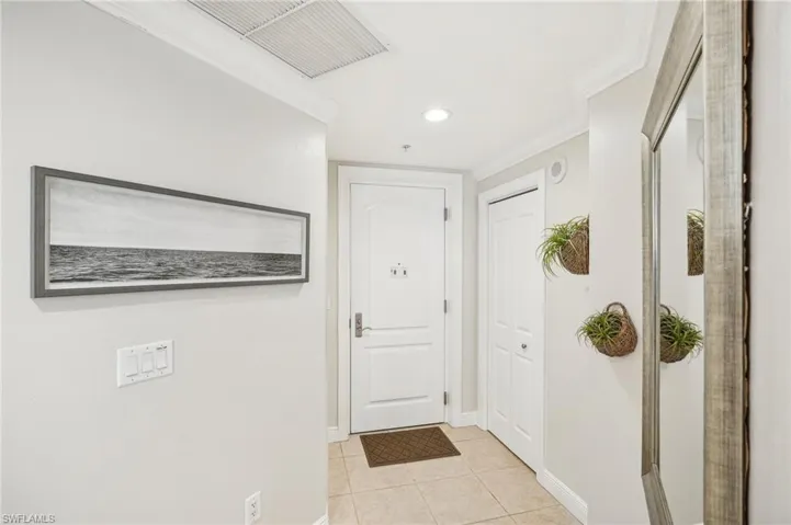 Entryway featuring crown molding and light tile patterned flooring