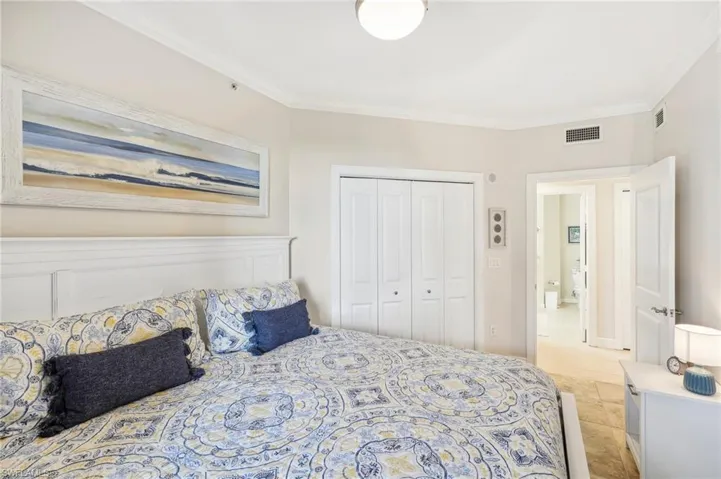 Bedroom featuring ornamental molding, a closet, and light tile patterned floors