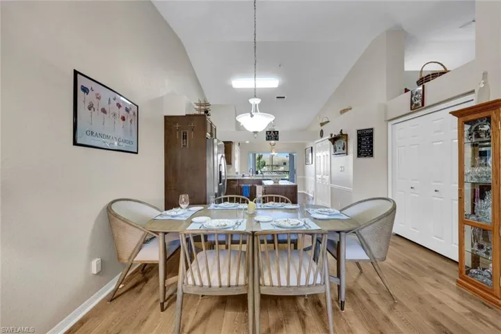 Dining room with light hardwood / wood-style flooring and high vaulted ceiling