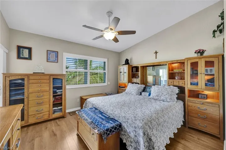 Bedroom with ceiling fan, light hardwood / wood-style flooring, and lofted ceiling