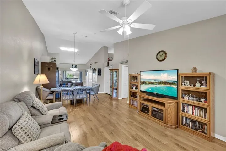 Living room featuring ceiling fan, light hardwood / wood-style floors, and high vaulted ceiling