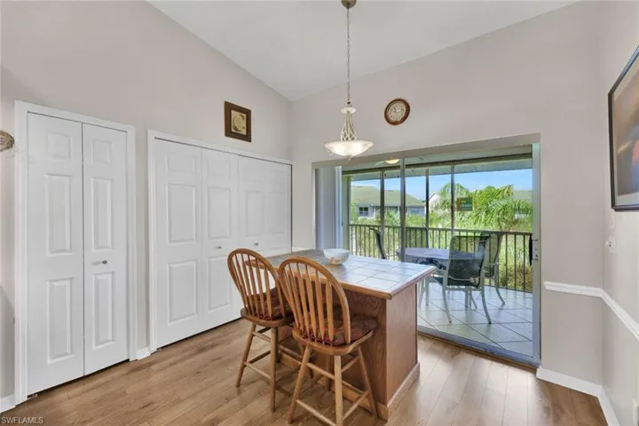Dining area featuring high vaulted ceiling and light hardwood / wood-style flooring