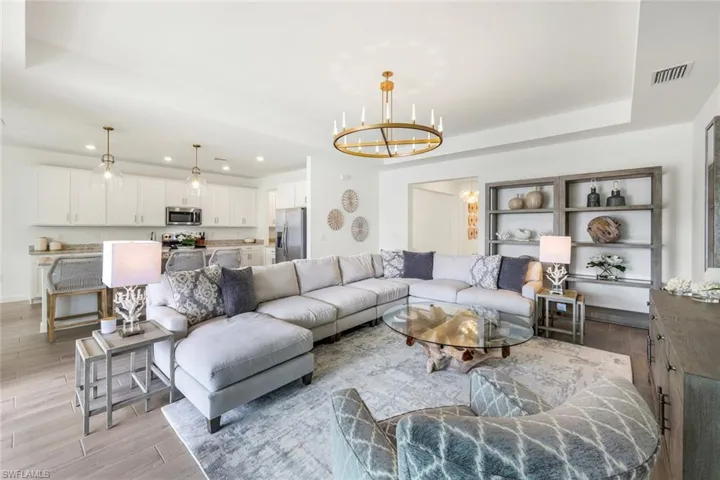Living room with a notable chandelier and a tray ceiling