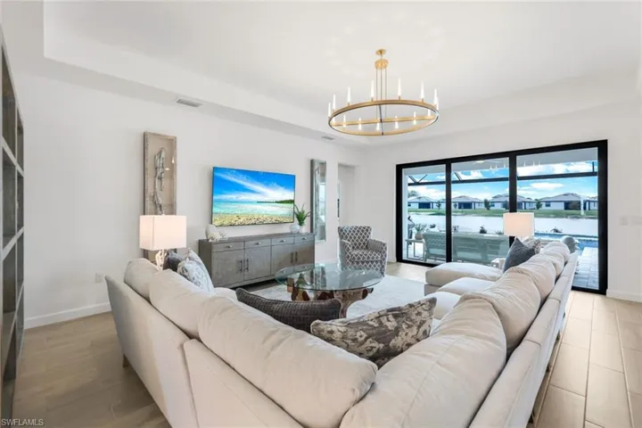 Living room with a notable chandelier and a tray ceiling