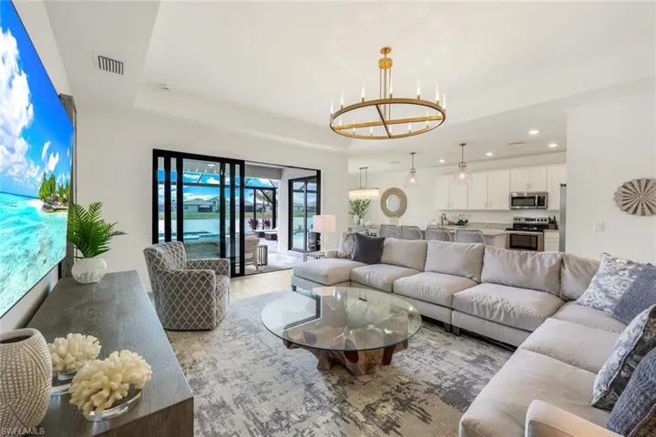 Living room with a notable chandelier and a tray ceiling
