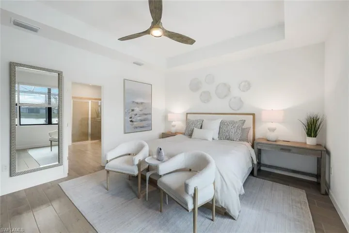 Master Suite with a tray ceiling, ceiling fan, and ensuite bathroom