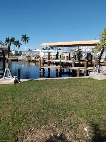 View of dock with a water view and a yard